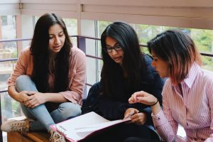 Three female students looking at school work