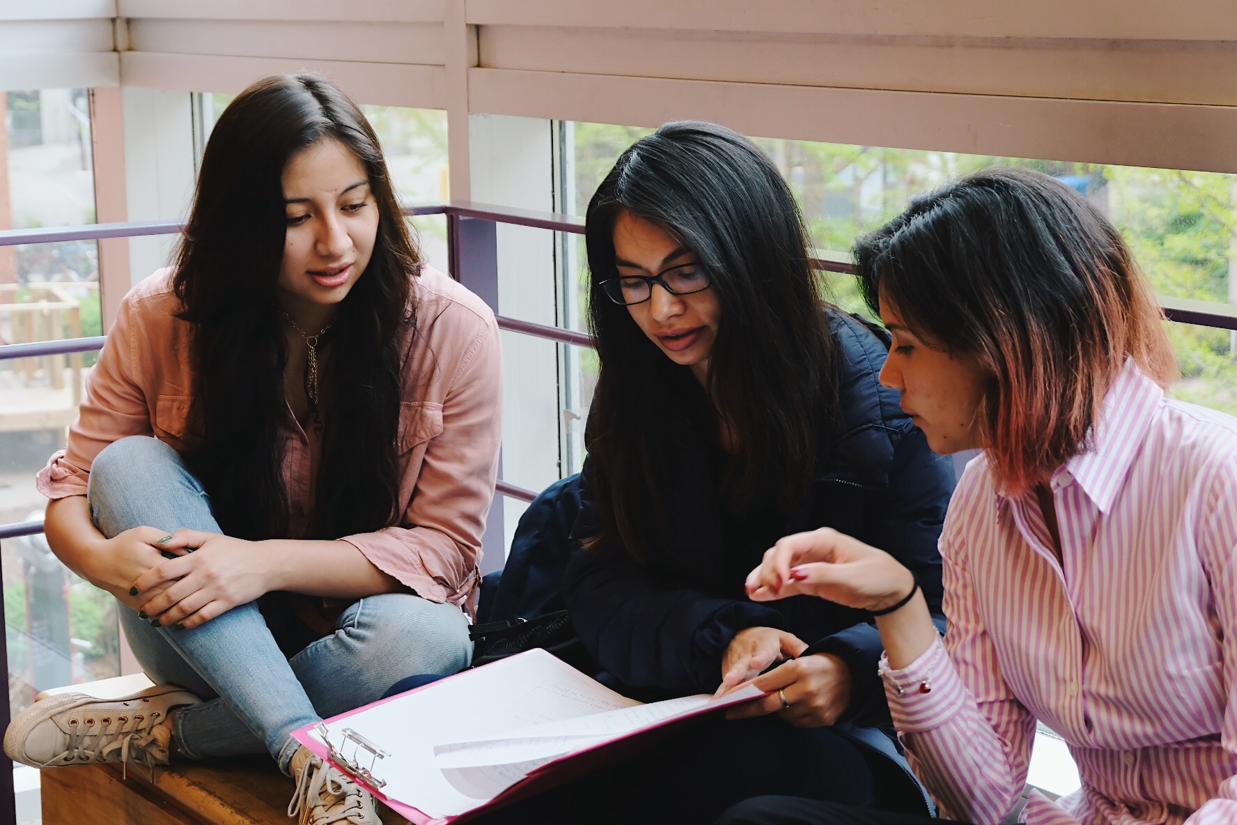 Three female students looking at school work