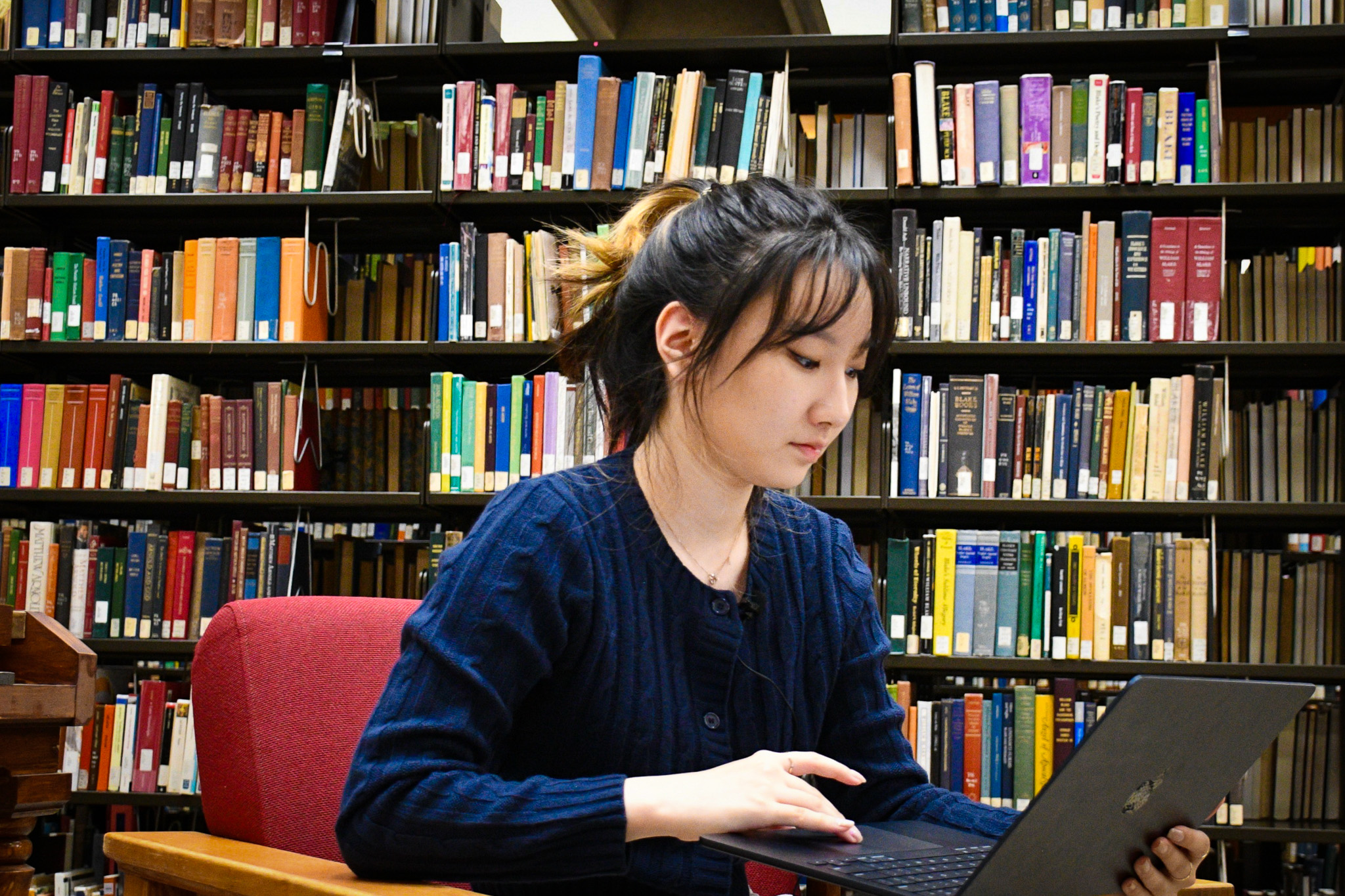 Student uses a laptop in a library.